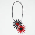 Necklace with black and red flower pendants on a white background