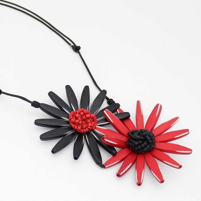 Necklace with black and red flower pendants on a white background