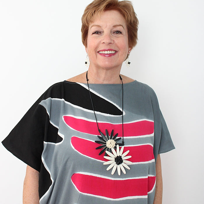 woman wearing a chunky flower necklace in black and white
