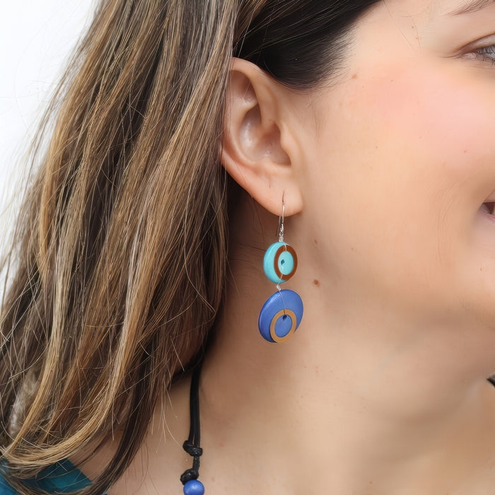 Close-up of a woman wearing colorful circular earrings with a blurred background