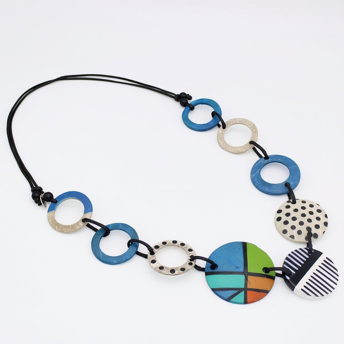 Necklace with blue and polka dot circular pendants on a white background