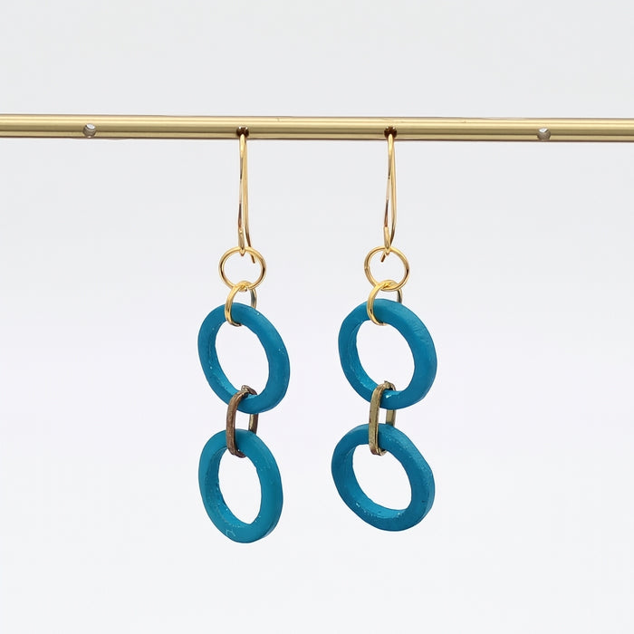 Pair of turquoise earrings with gold hooks on a white background