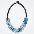 Necklace with black beads and blue circular beads on a white background