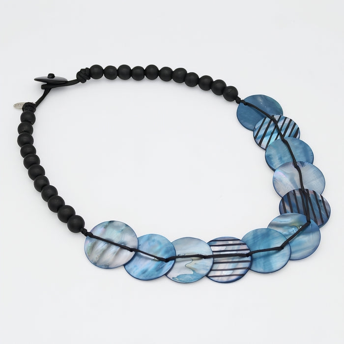 Necklace with black beads and blue disc beads on a white background