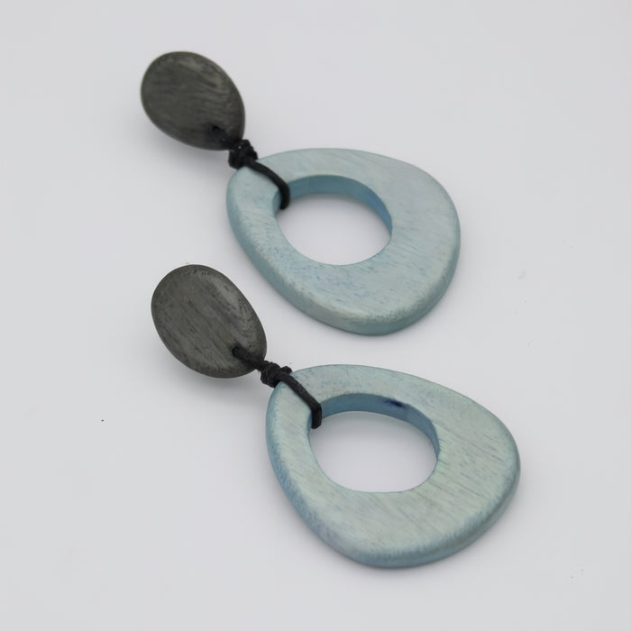 Pair of earrings with blue and charcoal circular designs on a white background
