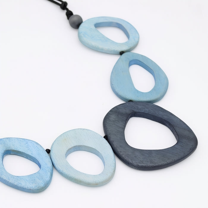 Necklace with blue and gray wooden beads on a white background