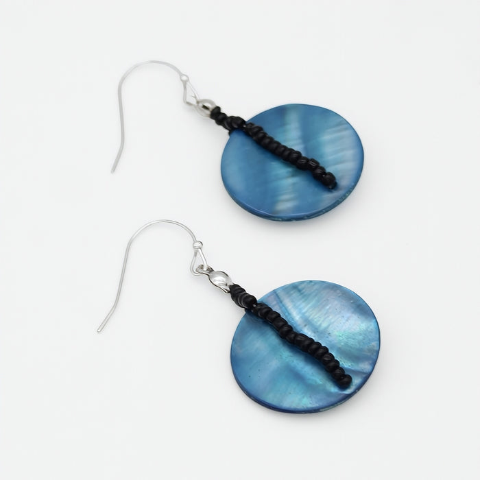 Pair of blue circular earrings with black beads on a white background