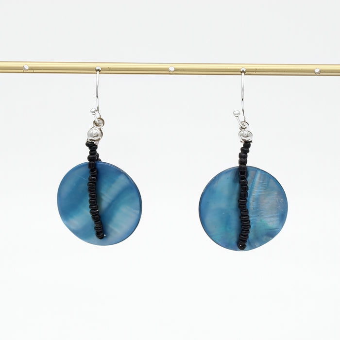 Pair of blue circular earrings with black beads on a white background