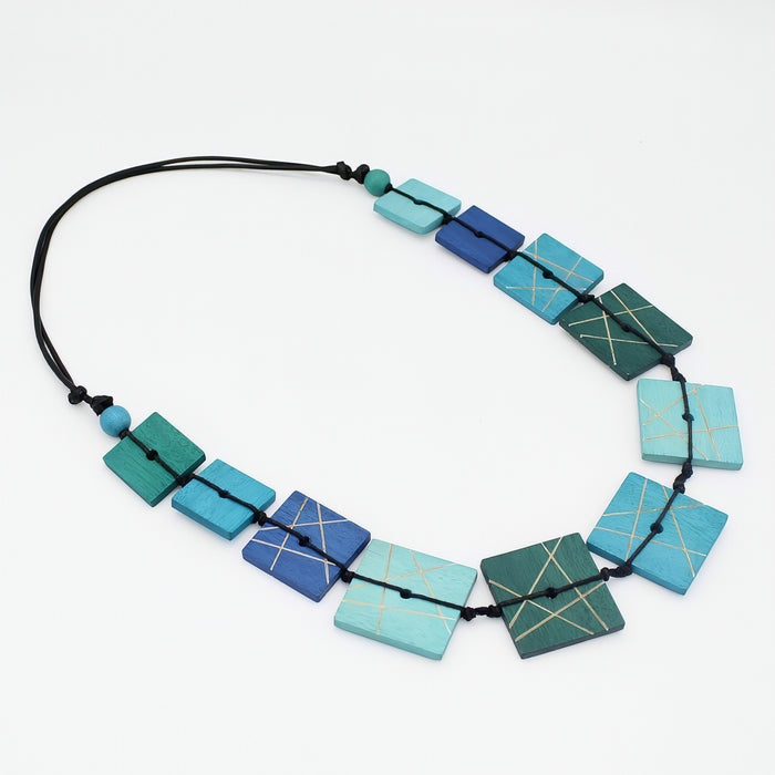 Necklace with geometrically patterned blue and green beads on a white background