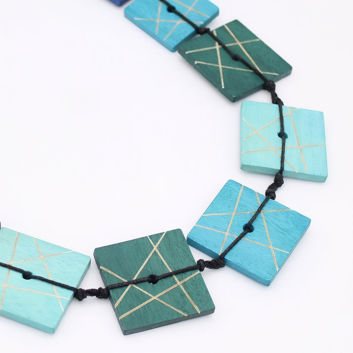 Necklace with square turquoise and green beads on a white background