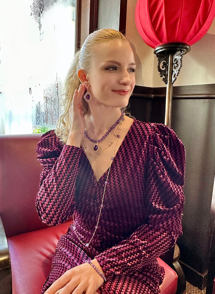 This finely crafted necklace features dual layers of delicate metal chains adorned with mesmerizing amethyst stones, creating a harmonious balance between sophistication and natural beauty.