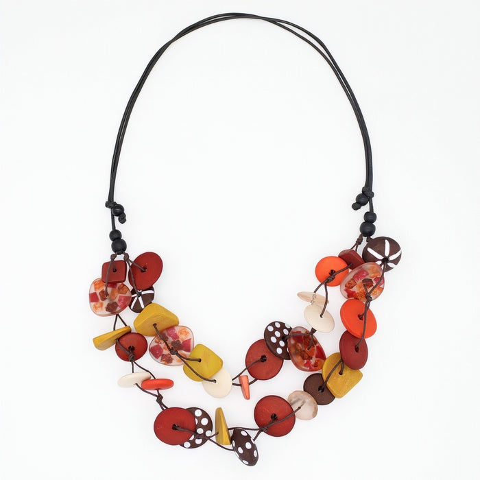A multi-strand statement necklace featuring colorful faux buttons in red, orange, yellow, brown, and white, strung on a black cord against a plain white background.