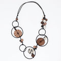 Necklace with circular beads and wooden elements on a white background