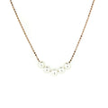 A rose gold vermeil necklace with five pearls placed along the chain, worn by a model.