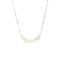 A sterling silver necklace with a chain link design and five rounded freshwater pearls placed along the length of the chain.