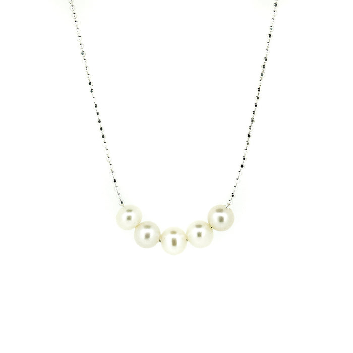 A sterling silver necklace with a chain link design and five rounded freshwater pearls placed along the length of the chain.