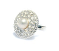 A sterling silver ring with a detailed circular design and a central white freshwater pearl, isolated on a white background.