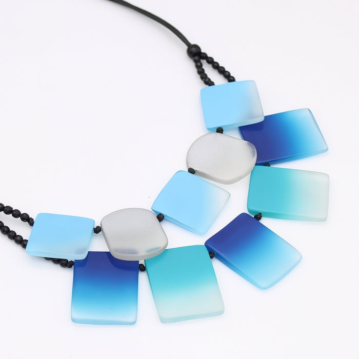 Necklace with blue and gray square beads on a white background