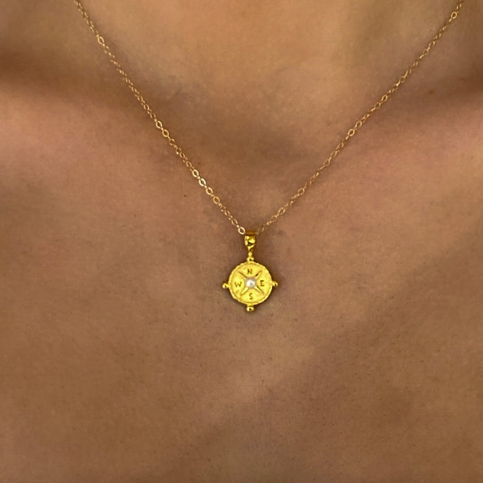 gold compass pendant with pearl detail