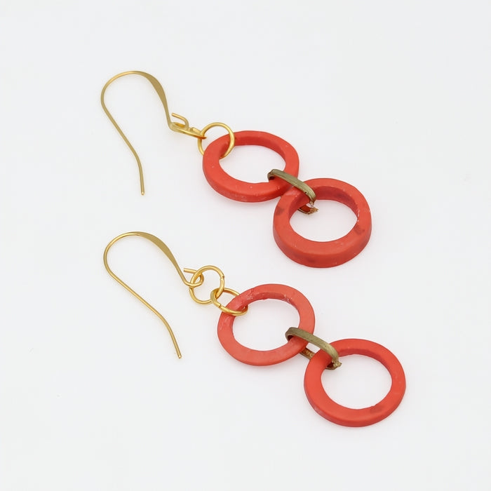 Red circular earrings with gold hooks on a white background