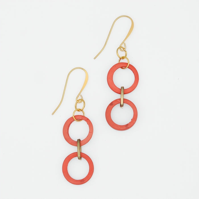 Pair of earrings with red circular links and gold hooks on a white background