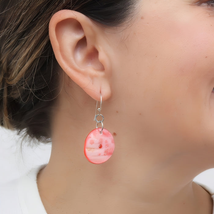 Close-up of a pink earring worn by a person