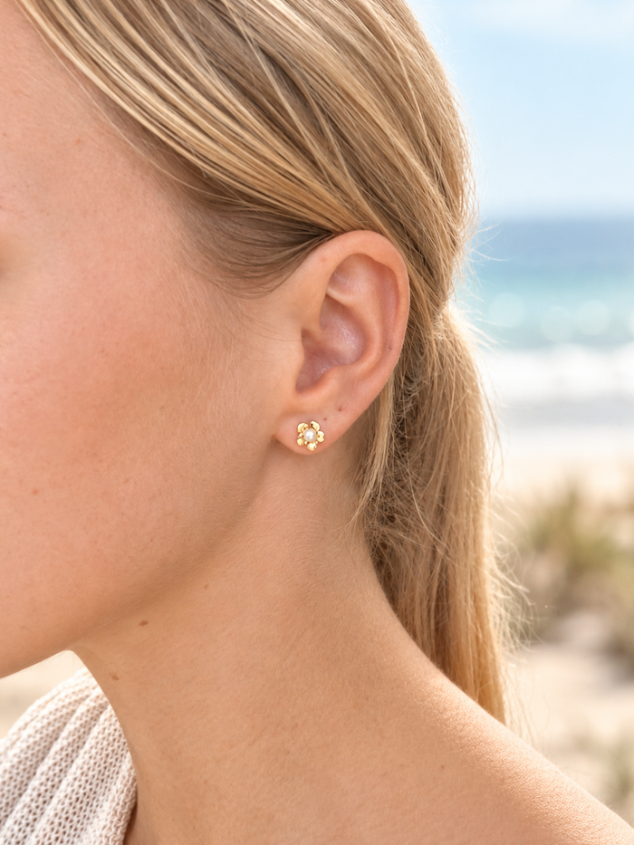 Model wearing Dainty Frangipani Pearl Stud Earrings in gold vermeil and freshwater pearl