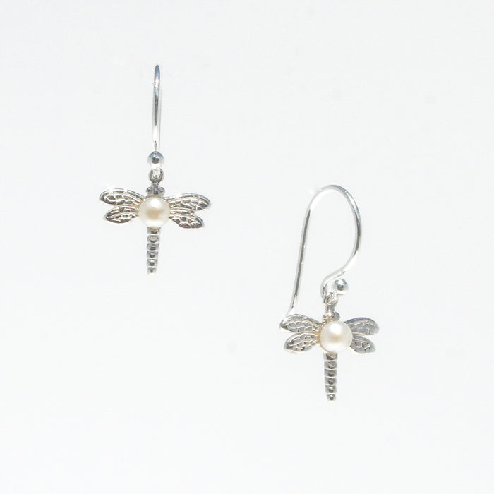 A pair of sterling silver hook earrings featuring a detailed dragonfly design with a freshwater pearl positioned at the center of the dragonfly's body.