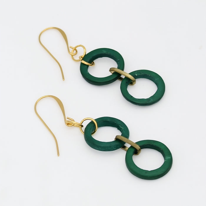 Green and gold earrings on a white background