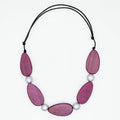 Necklace with pink wooden beads and white pearls on a white background