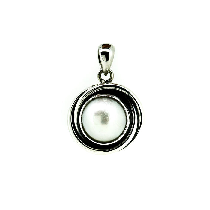 silver pendant with central pearl with swirls of silver reminscent of a sunset