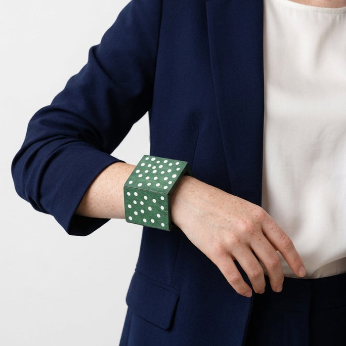 Bold green wooden chunky bangle with white polka dots on a stretch cord. One size fits most — easy to stack or wear solo. Shop Sylca Designs.