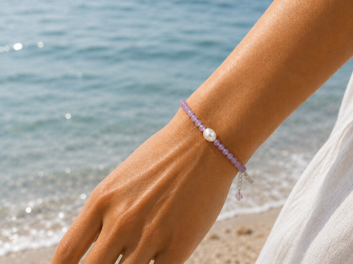 Alt Text:
Pink pearl gemstone bracelet with faceted blush beads, genuine freshwater pearl, sterling silver adjustable chain, and LUSH tag worn on a sun-kissed wrist by the ocean.