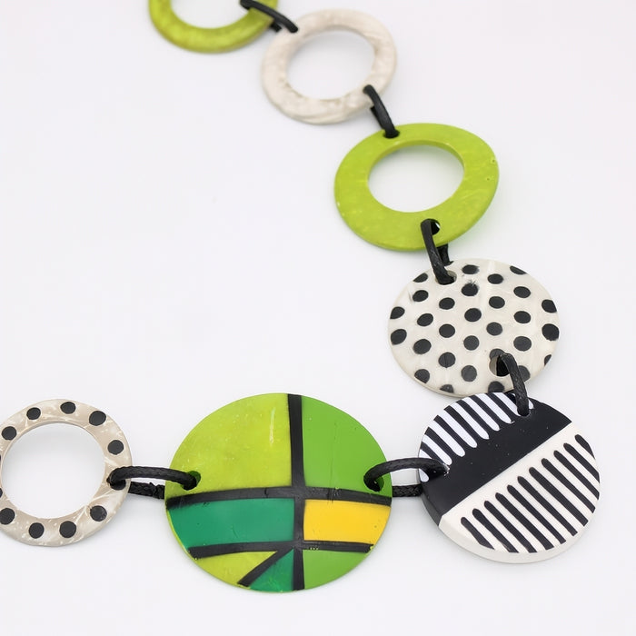 Colorful coconut shell necklace with various patterns on a white background
