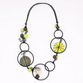 Necklace with circular beads and green accents on a white background