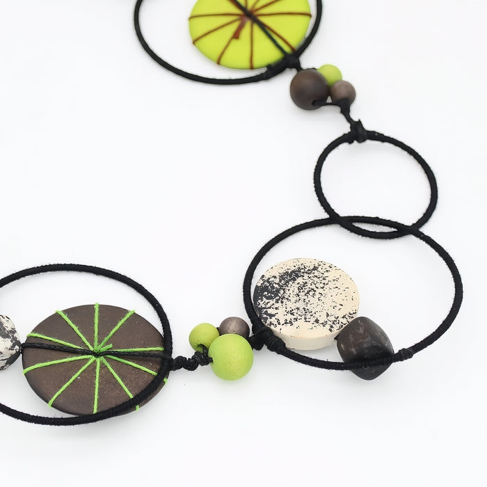 Necklace with circular beads and green accents on a white background