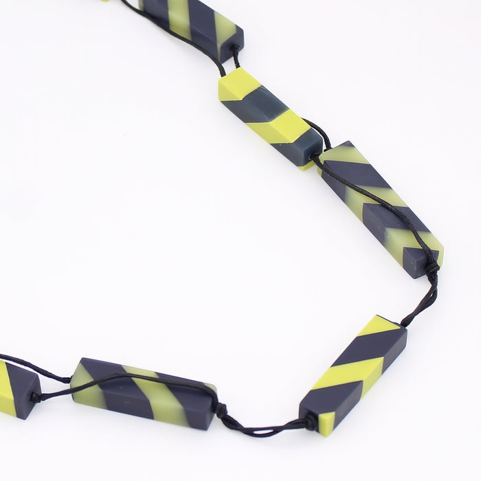 Necklace with black and yellow striped beads on a white background