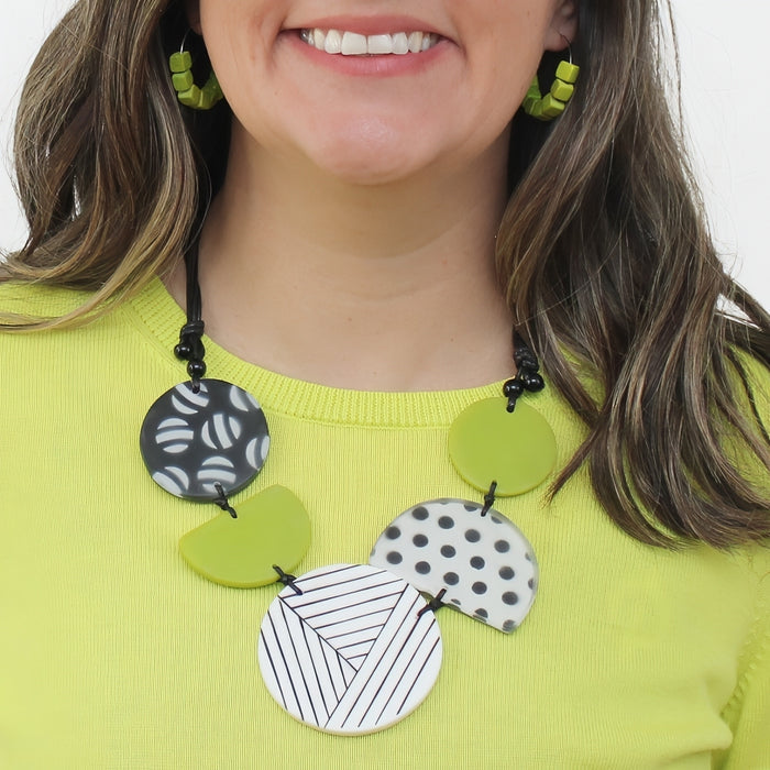 Person wearing a colorful necklace with geometric patterns on a white background