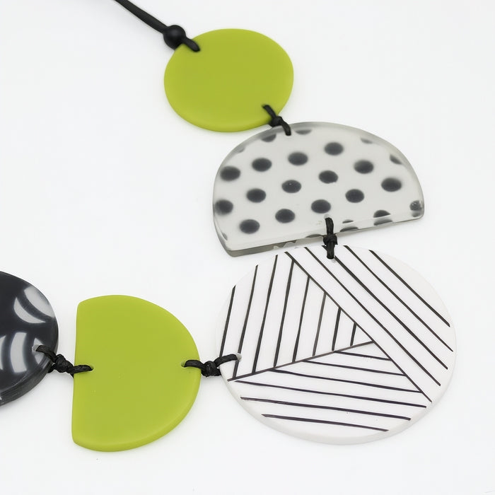 Set of geometrically patterned ceramic necklaces on a white background