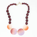 Necklace with wooden and gradient beads on a white background
