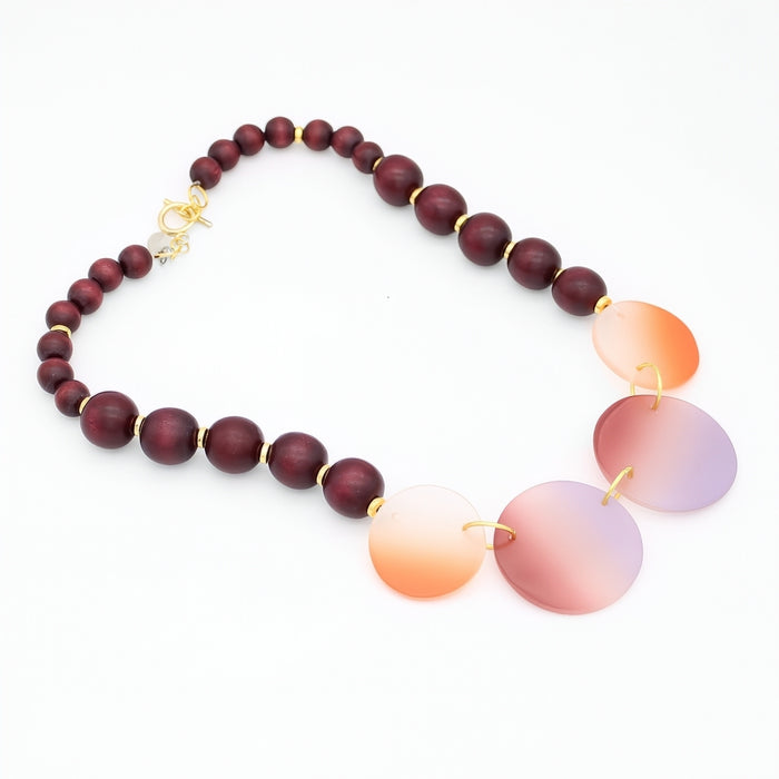 Necklace with wooden beads and gradient glass pendants on a white background