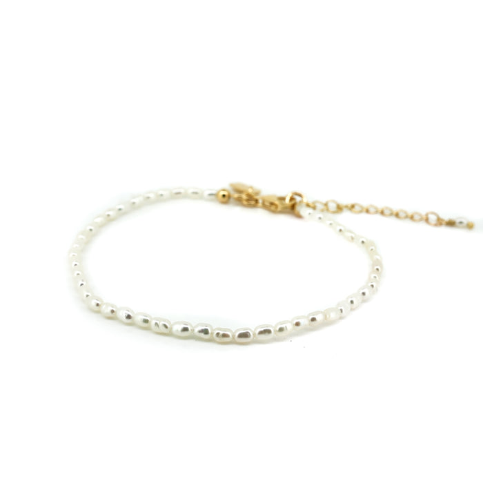 A dainty children's bracelet with white rice freshwater pearls and a gold vermeil clasp.