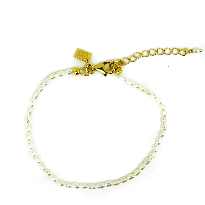 Rice pearl bracelet with gold-colored clasp and chain details.
