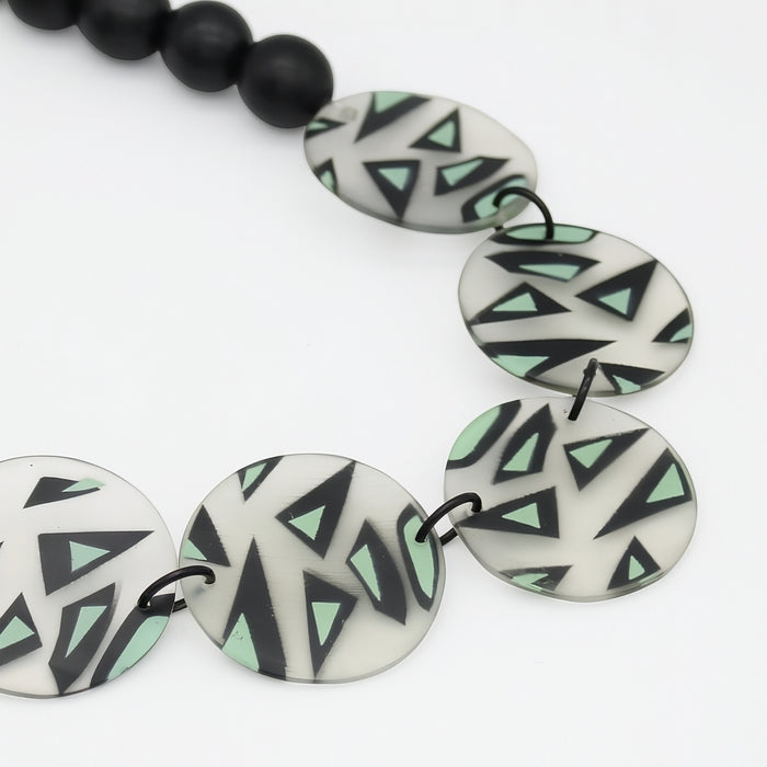 Close view of mint black and ivory geometric necklace discs