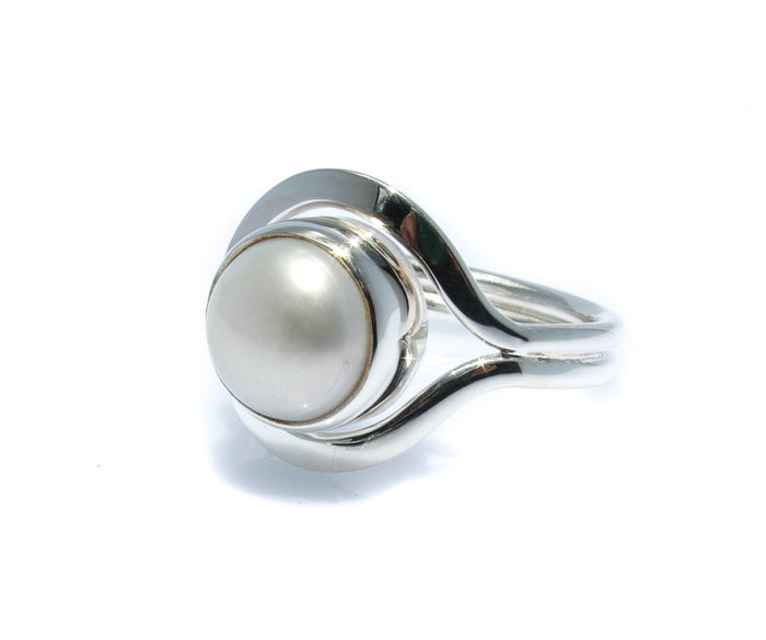 A white freshwater pearl ring set in a silver bezel, with a design reminiscent of a Cable Beach Sunset.