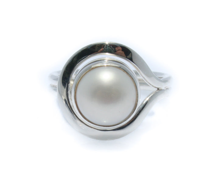 A white freshwater pearl ring set in a silver bezel, with a design reminiscent of a Cable Beach Sunset.