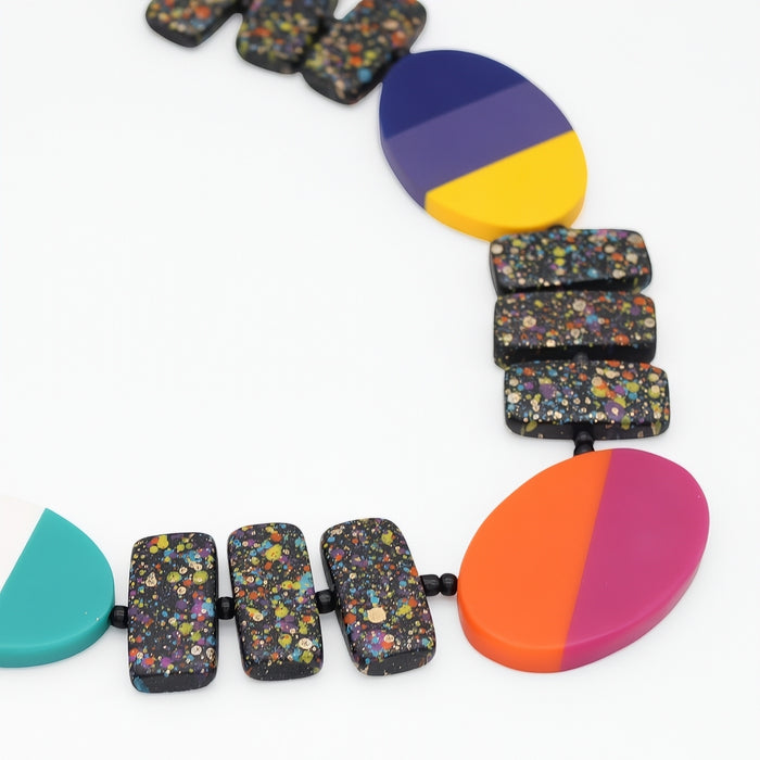 Colorful necklace with multicolored beads and large circular pendants on a white background