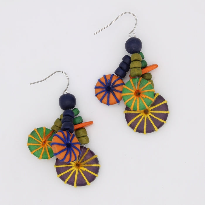 Colorful earrings with circular designs on a white background