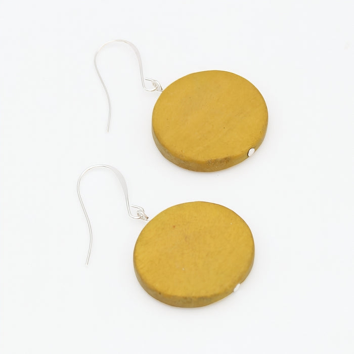 Mustard yellow round earrings on a white background