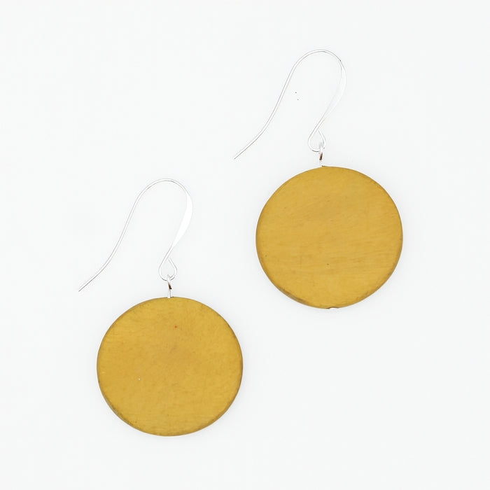 Mustard yellow circular earrings on a white background